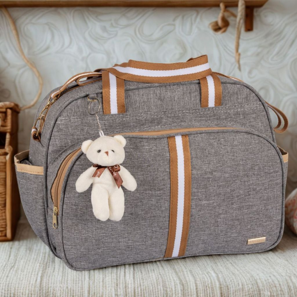 Bolsa Maternidade Com Chaveiro cinza com marrom num sofa