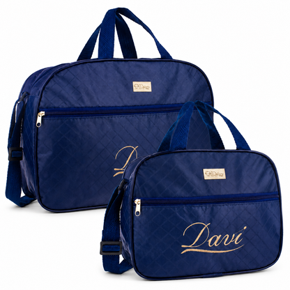 Duas bolsas de maternidade azul-escuro com textura matelassê e bordado dourado personalizado.