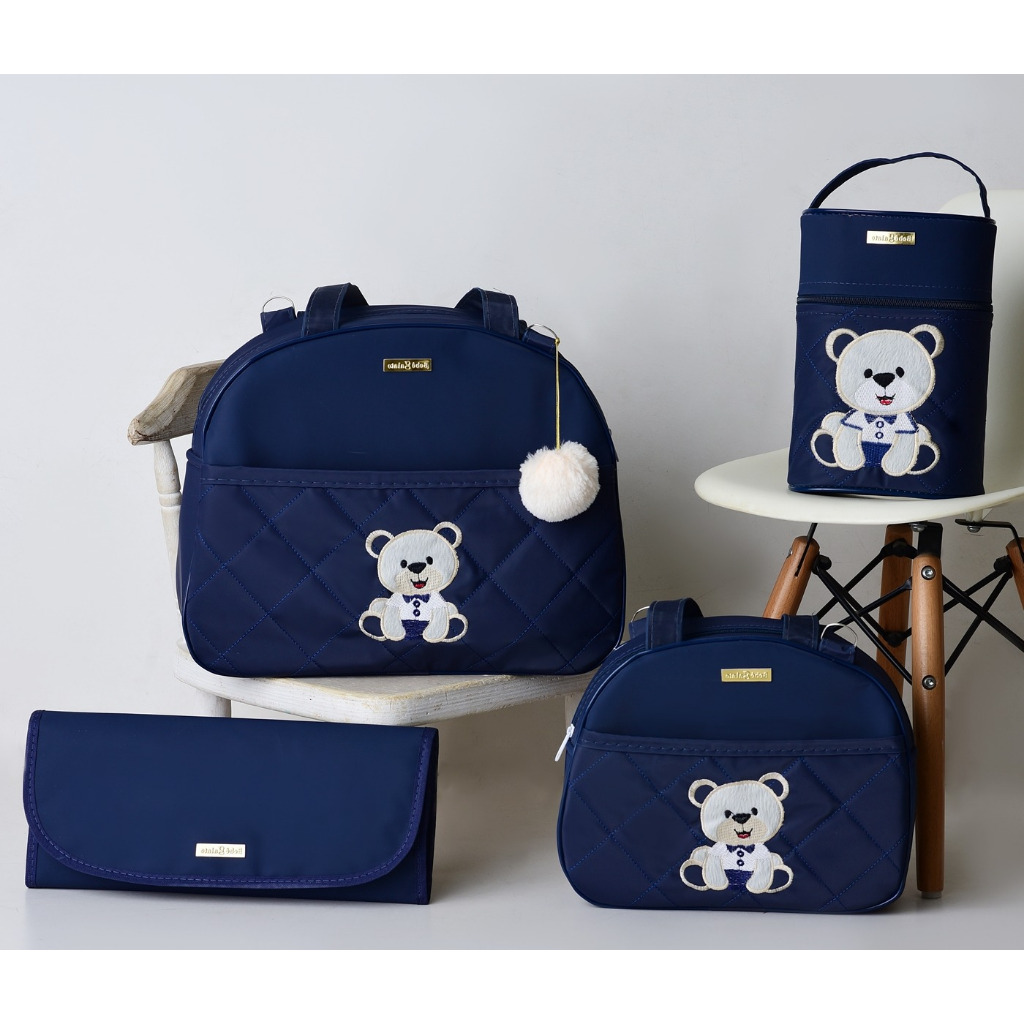 Kit Bolsas Maternidade Ursinho Feliz azul marinho numa cadeira