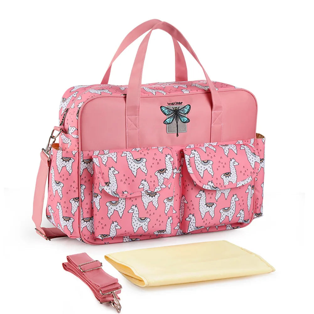 Bolsa maternidade rosa retangular com estampa de lhamas, alça transversal e trocador amarelo.