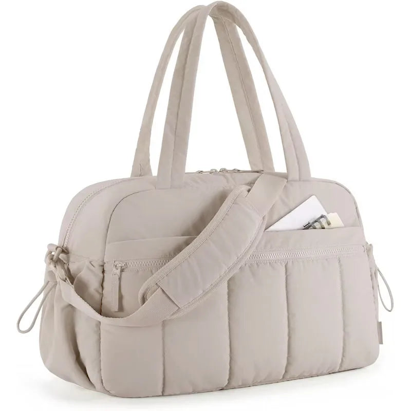 Bolsa acolchoada bege claro vista de lado, com alças de mão e de ombro.