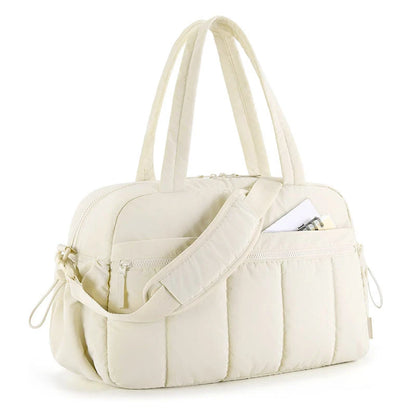 Bolsa acolchoada creme com alças de mão e ombro em vista diagonal.