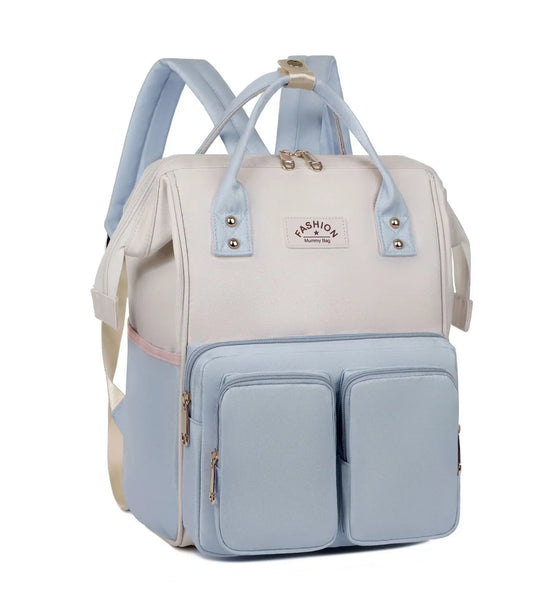**Alt Text:** Mochila maternidade impermeável azul e bege com bolsos, em ângulo de três quartos.