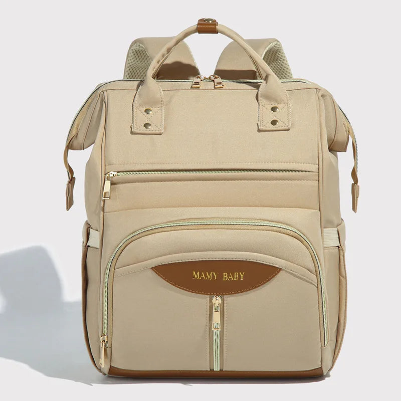 Mochila de maternidade bege clara, vista frontal, com zíperes dourados e detalhes marrons.