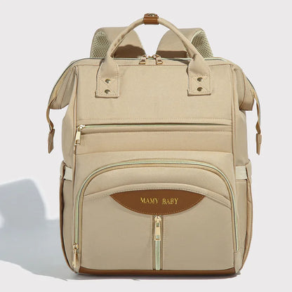Mochila de maternidade bege clara, vista frontal, com zíperes dourados e detalhes marrons.
