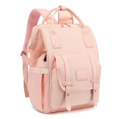 Mochila de maternidade rosa claro estruturada com bolso frontal, vista em perspectiva diagonal.