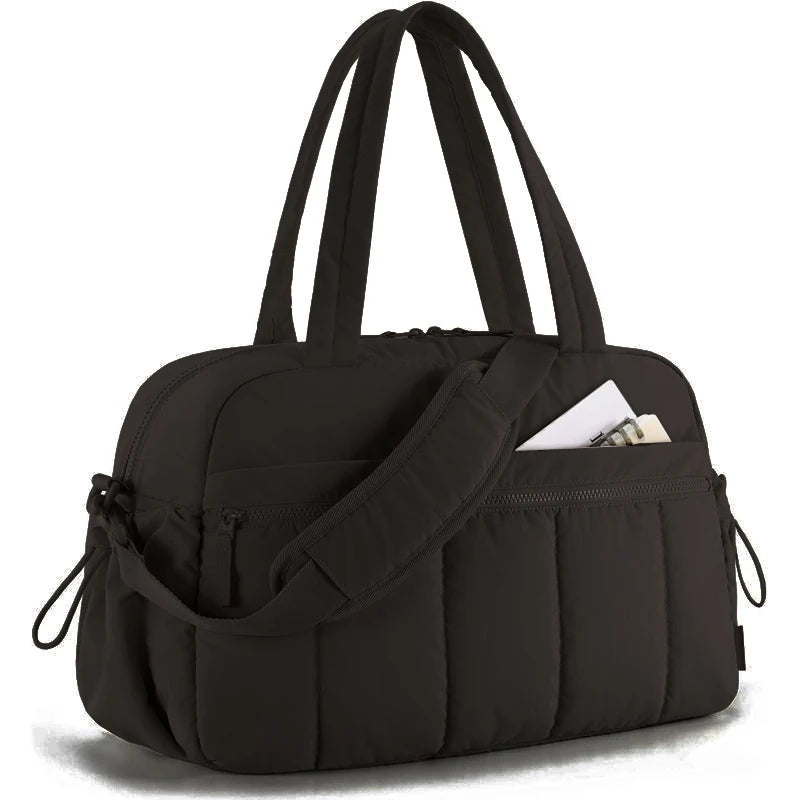 Bolsa preta acolchoada com alça de ombro, vista em ângulo de três quartos.