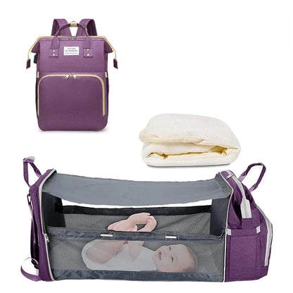 Mochila maternidade roxa mostrada fechada, com colchonete dobrado e aberta como berço portátil.
