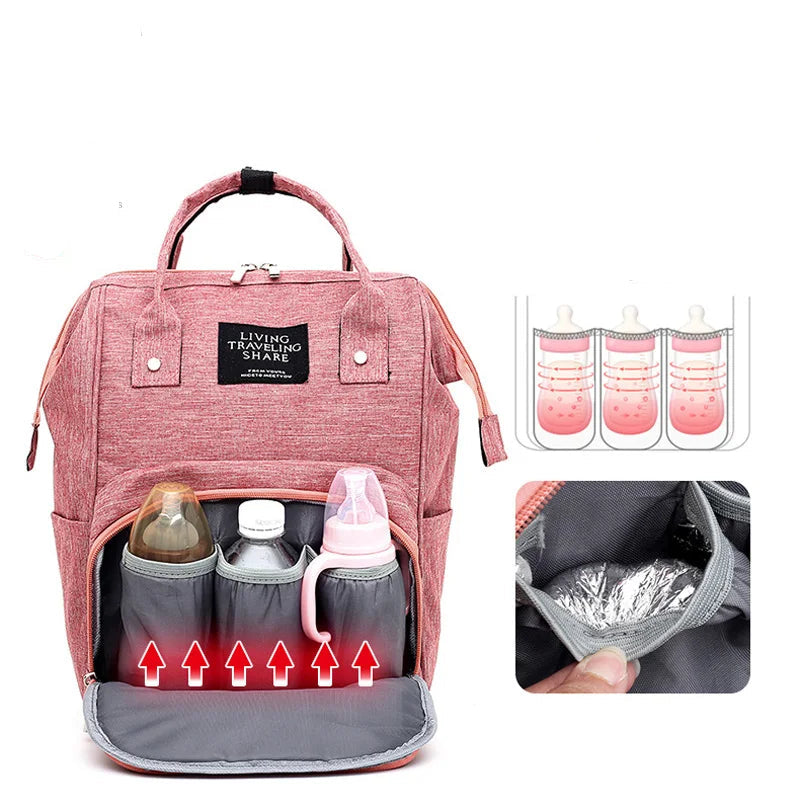 Mochila de maternidade rosa vista de frente com bolso aberto exibindo suporte para mamadeiras
