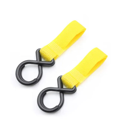 Par de ganchos pretos com fitas amarelas de velcro sobre fundo branco.