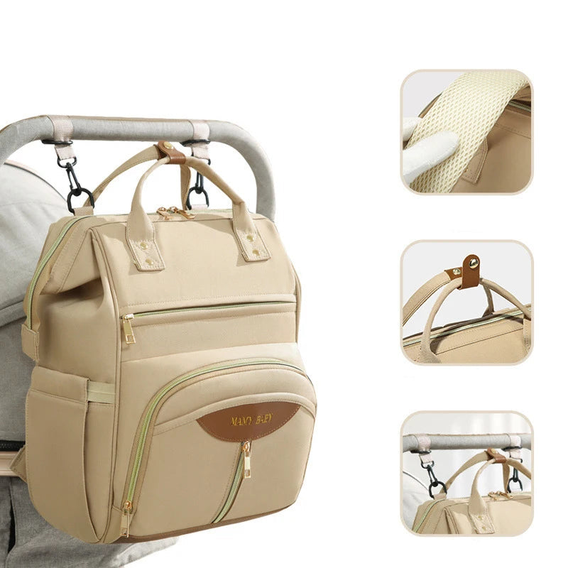 Mochila maternidade bege pendurada no carrinho, com três detalhes à direita.