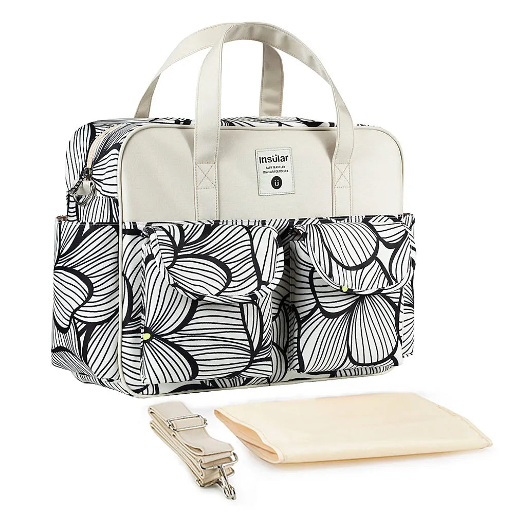 Bolsa maternidade com estampa abstrata preta e branca, detalhes beges, alça removível e trocador.