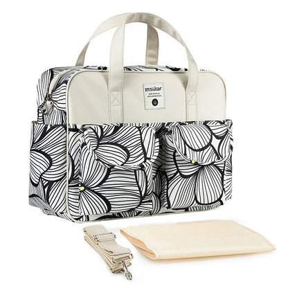 Bolsa maternidade com estampa abstrata preta e branca, detalhes beges, alça removível e trocador.