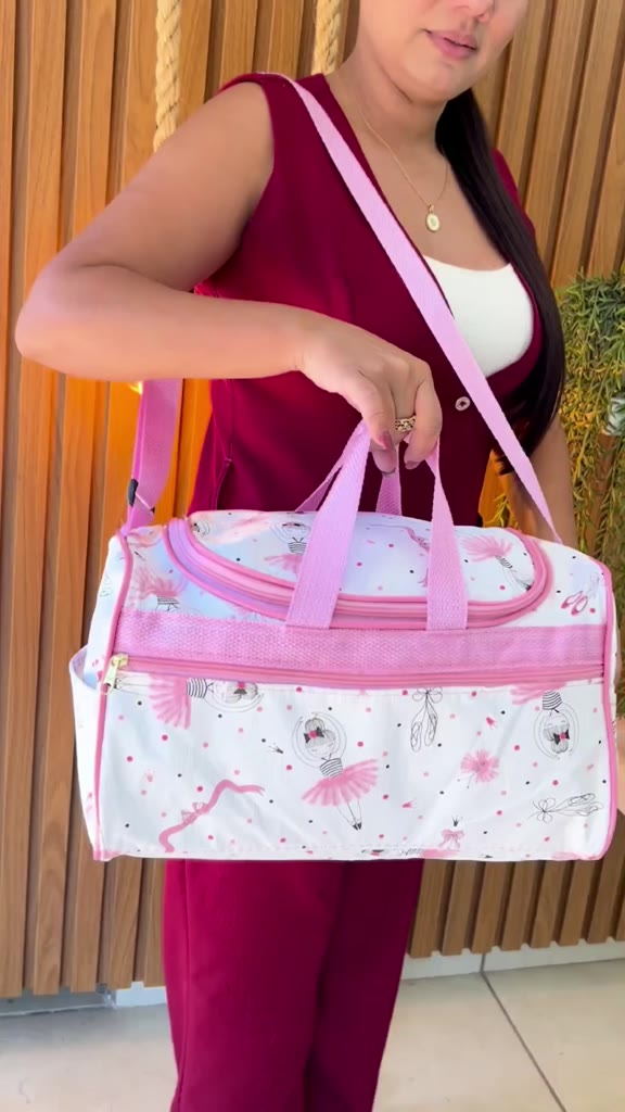 Bolsa maternidade branca com estampa de bailarinas rosa, alça de ombro e de mão.