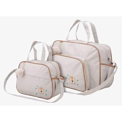Duas bolsas de maternidade beges com detalhes marrons, bordado de leão e chaveiros pompom.