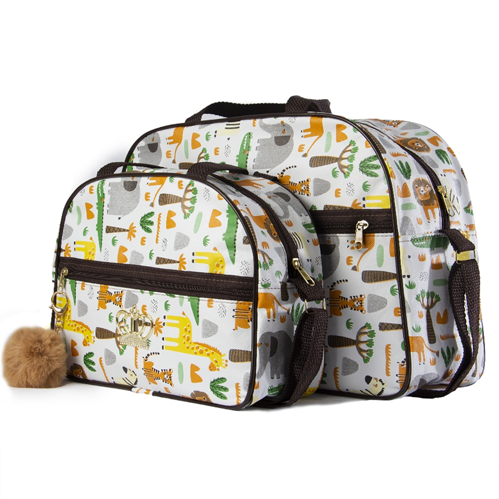 Duas bolsas de maternidade brancas com estampa safari, alças marrons e chaveiro pompom lateral.