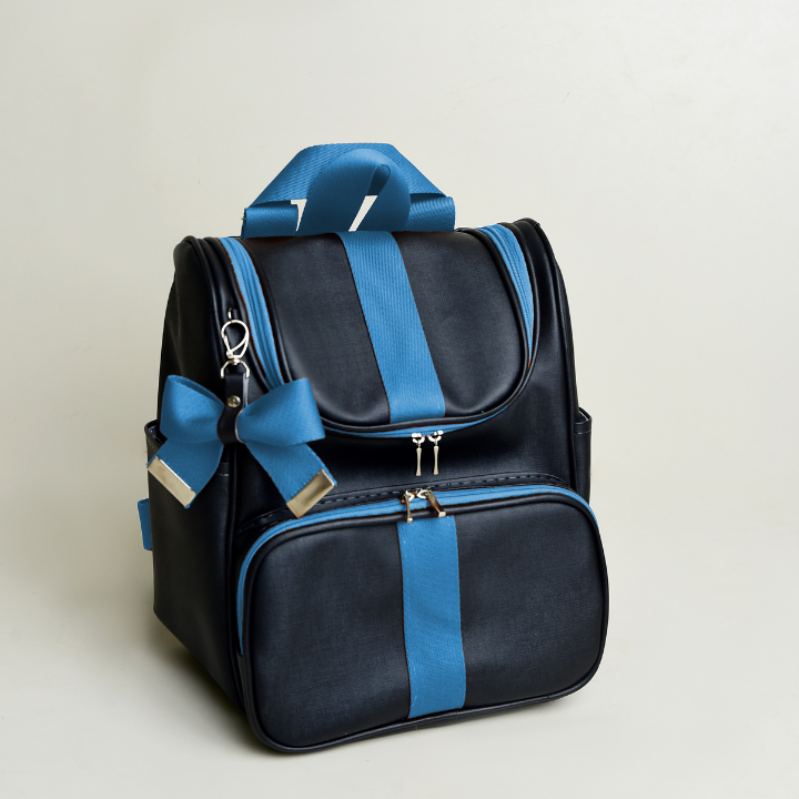 Mochila preta com detalhes azuis e chaveiro de laço vista de frente.
