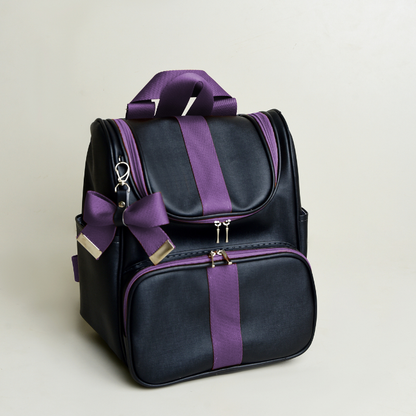 Mochila preta com detalhes e laço roxos, fotografada em ângulo sobre fundo claro.