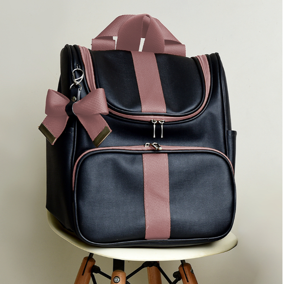 Mochila preta estruturada com detalhes e laço em rosa-antigo, vista de frente.