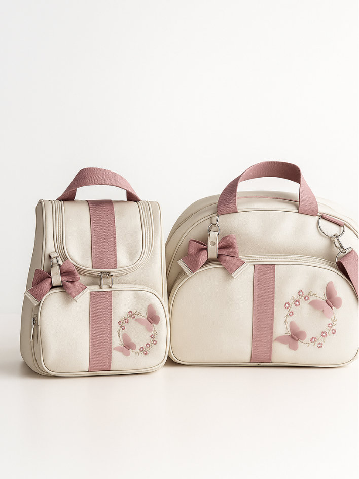Kit de mala e mochila beges com detalhes rosa e bordados de borboleta.