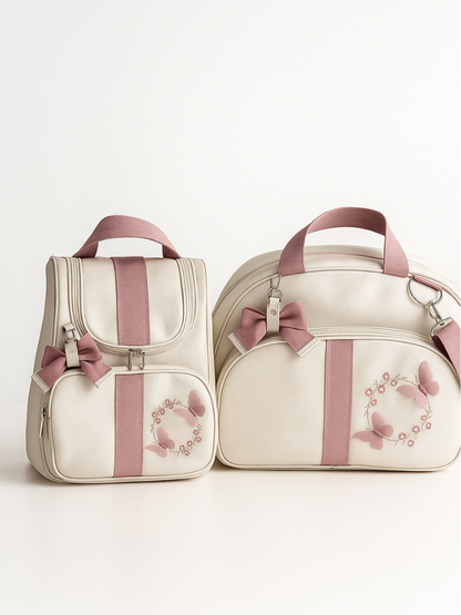 Kit de mala e mochila beges com detalhes rosa e bordados de borboleta.