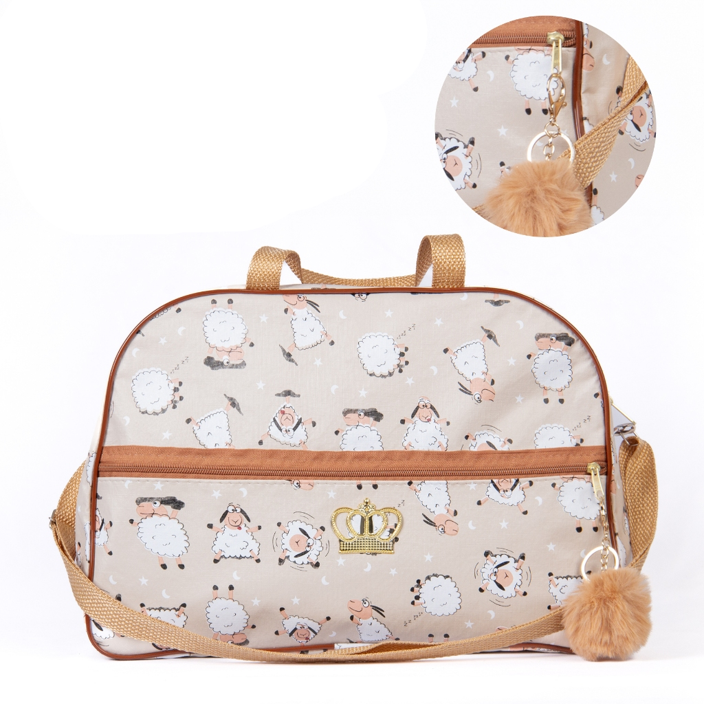 Bolsa de maternidade bege com estampa de ovelhas, coroa dourada e chaveiro de pompom.