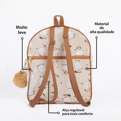 Mochila bege com estampa de ovelhas, alças marrons ajustáveis e chaveiro de pompom.