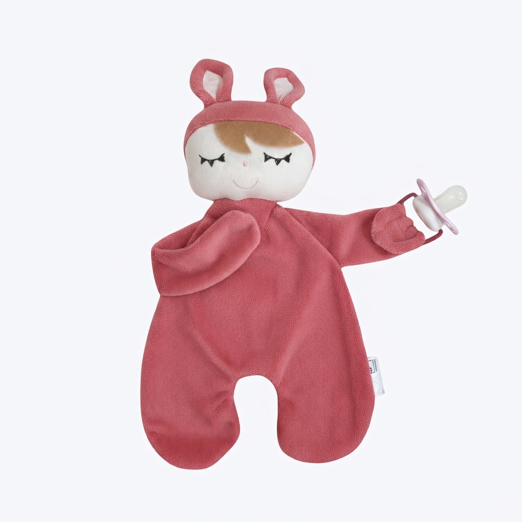 Visão frontal de naninha rosa de bebê com capuz de coelho segurando uma chupeta.