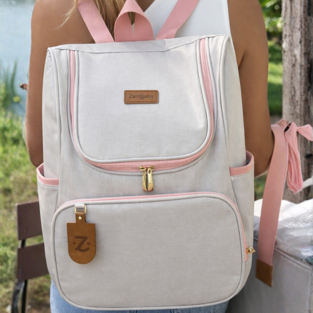 Mochila de maternidade em linho cinza com alças e detalhes em rosa.