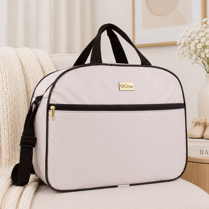 Bolsa de maternidade bege-clara com alças pretas e zíper frontal, vista de frente.