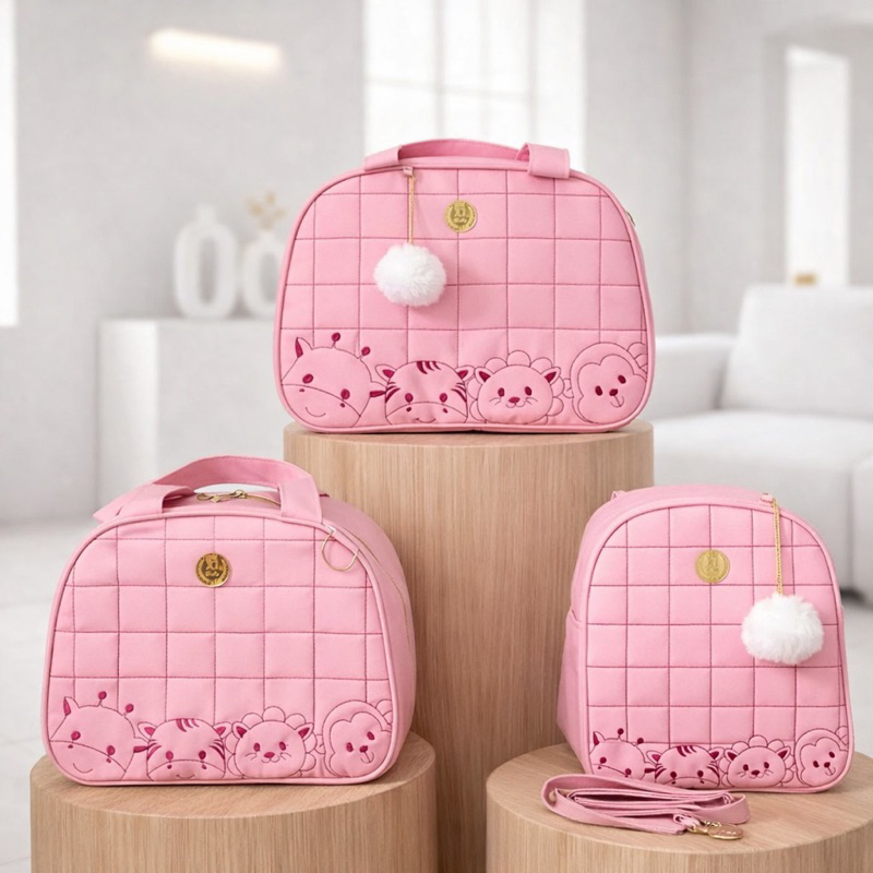 Três bolsas de maternidade rosa com bordados de animais sobre pedestais de madeira.