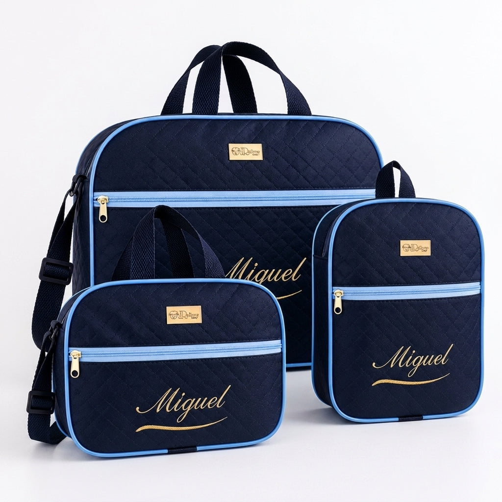 Kit de três bolsas de maternidade azul-marinho com detalhes azul-claro e bordado dourado.