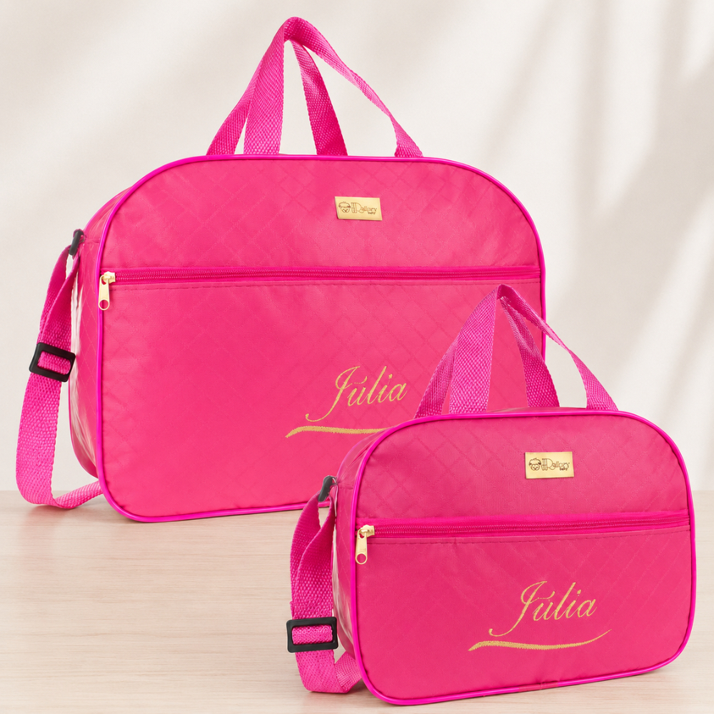 Duas bolsas maternidade rosa-choque personalizadas com nome Júlia em dourado sobre mesa clara.