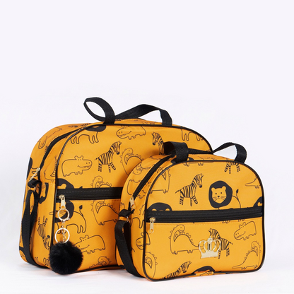 Duas bolsas de maternidade amarelas com estampa de animais pretos e chaveiro de pompom.