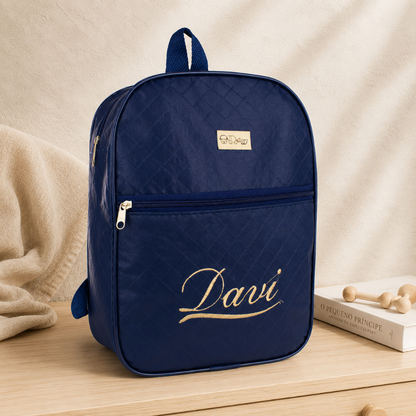 Mochila maternidade azul-marinho acolchoada com nome Davi em dourado, vista frontal.