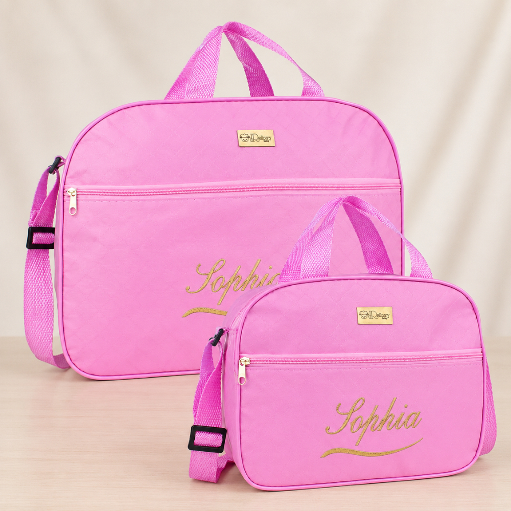 Duas bolsas de maternidade rosa personalizadas com nome dourado em ângulo frontal.