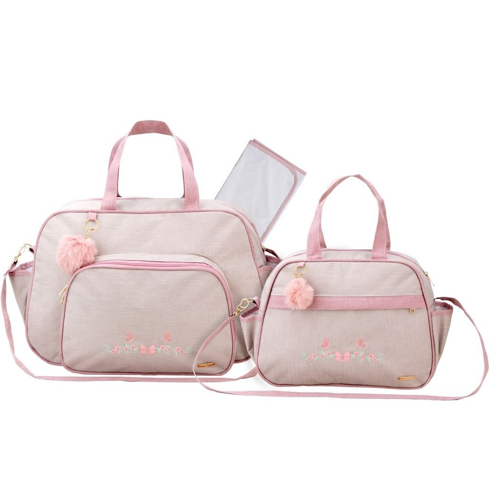Bolsas de maternidade bege com alças rosa, detalhes bordados de flores e trocador.