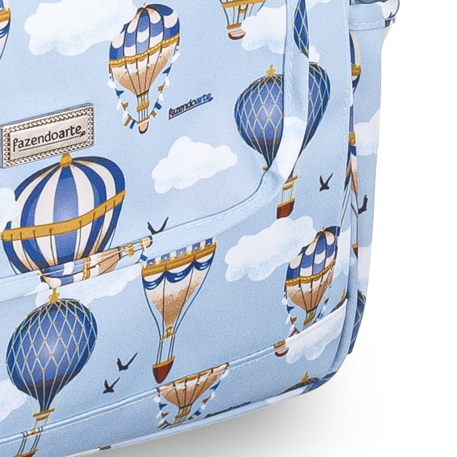 Detalhe aproximado de bolsa maternidade azul com estampa de balões e nuvens.