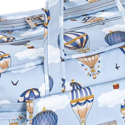 Detalhe em close-up de bolsa azul com estampa de balões e nuvens