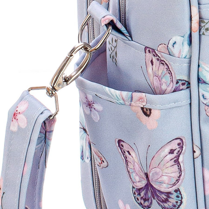 Detalhe de fecho metálico prateado em bolsa azul com estampa de borboletas.