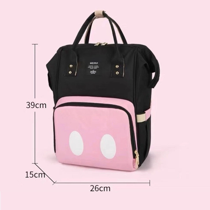 Mochila preta e rosa com indicações de medidas, vista de frente em fundo rosa.