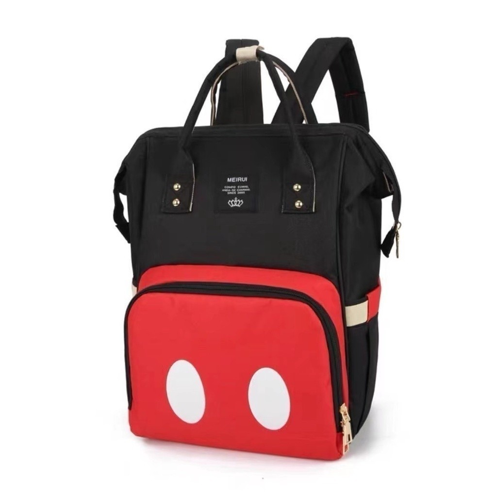 Mochila estruturada preta e vermelha com dois ovais brancos, vista em perspectiva frontal.