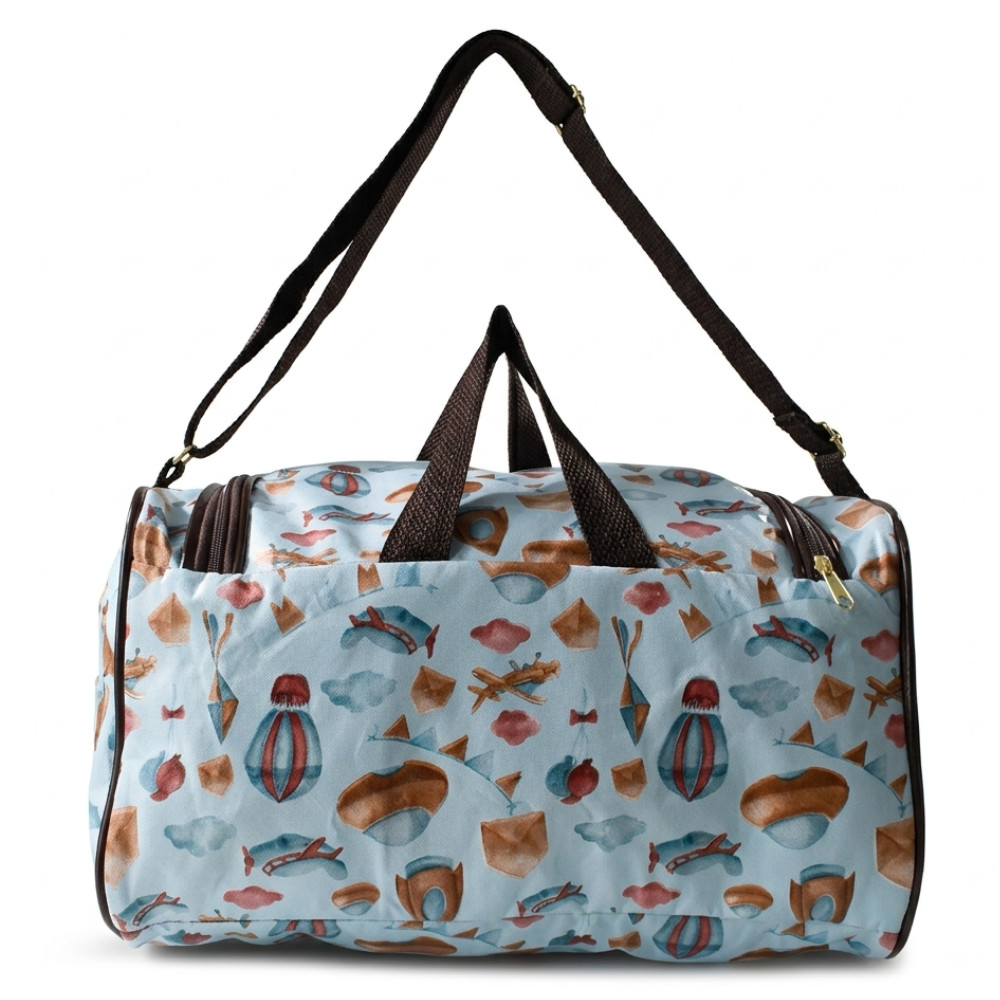 Bolsa maternidade azul estampada com balões e aviões, alça tiracolo marrom em fundo branco.