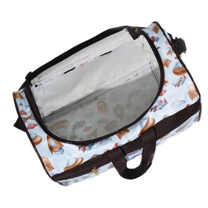 Bolsa maternidade azul estampada aberta em ângulo superior, exibindo amplo interior branco.