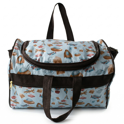 Bolsa de maternidade azul com estampas de foguetes, alças marrons e vista frontal.