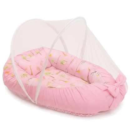 Ninho de bebê rosa com mosquiteiro arqueado, travesseiro estampado e detalhe de laço.