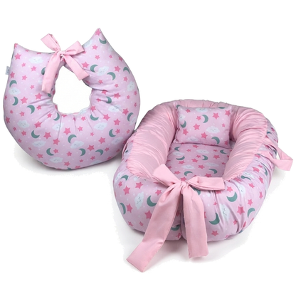 Ninho de bebê e almofada de amamentação rosa com estampas de estrelas e nuvens.