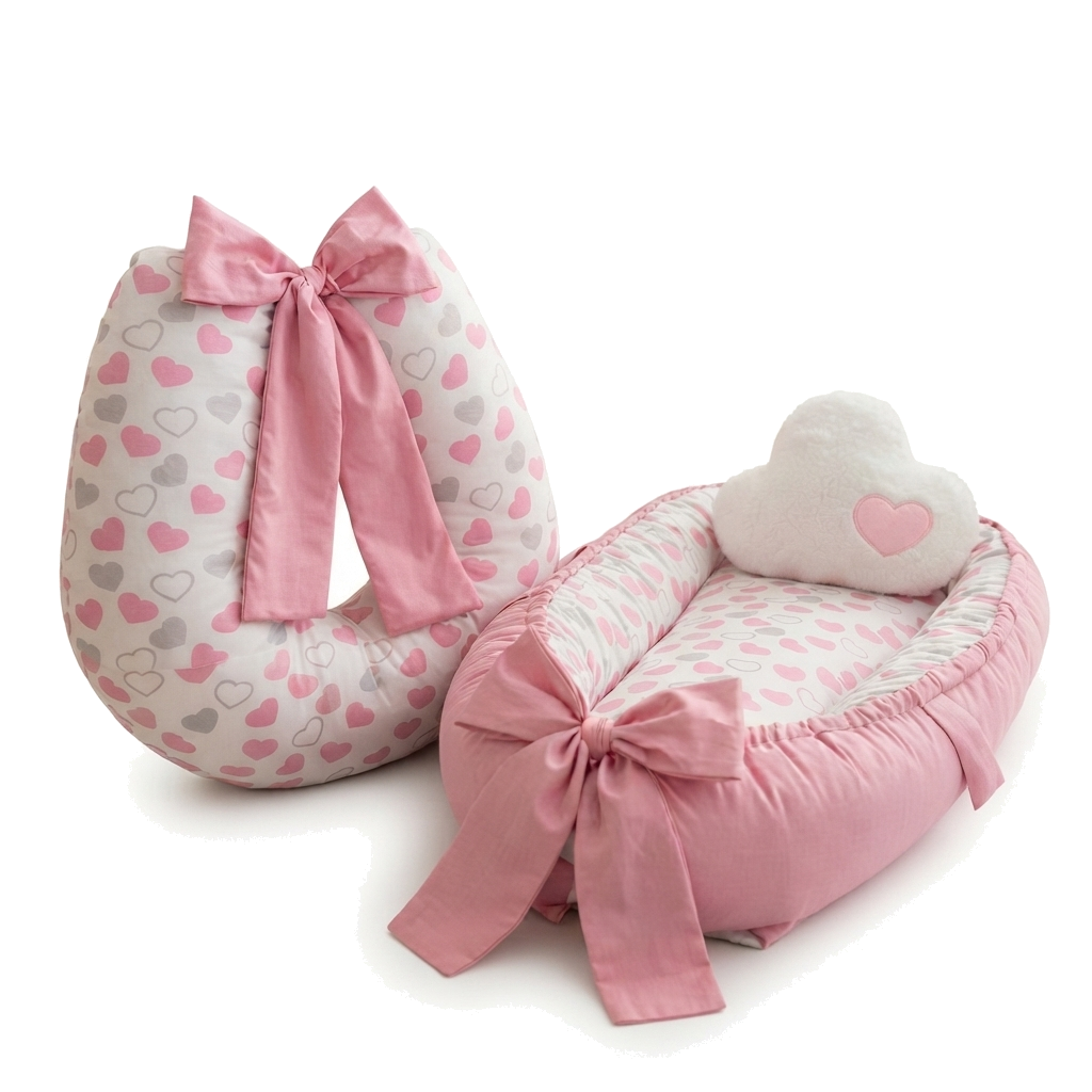 Almofada de amamentação e ninho de bebê rosa com estampa de corações e laços.