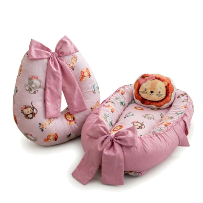 Ninho de bebê e almofada de amamentação rosa com estampa de safari e laços.
