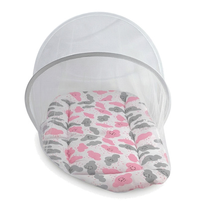 Ninho de bebê oval com colchonete de nuvens rosa e cinza sob mosquiteiro branco.